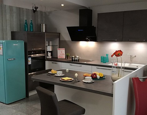 moderne L-Küche mit Arbeitsinsel und Sitzplatz - Koje 6 Lux Lack alpinweiß hochglanz/Riva beton grau