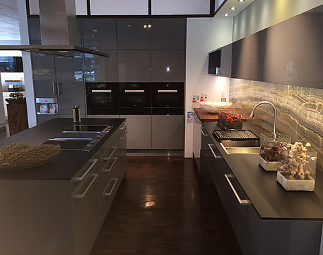 puristische Küche von poggenpohl in Steingrau mit Glas-Arbeitsplatte und Onyx-Natursteinrückwand - HL 1107 steingrau Hochglanz mit Griff S138