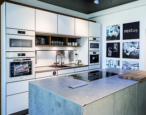 Musterküche mit vielen Miele Elektrogeräten - Glass matt Kristallweiß NX902/G092 und Ceramic Beton Grau Nachbildung NX950/C2075