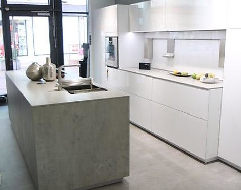 Monolithische Arbeitsinsel in Beton Keramik mit eleganter Küchenzeile in Lack Hochglanz und Gaggenau-Geräten - NX950 Ceramic beton grau + NX 310 Lack Hochglanz Kristallweiß