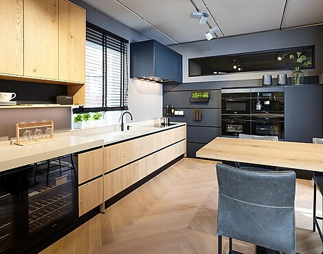 Schöne gemütliche Eckküche mit Komposit Arbeitsplatte und 10 Miele Geräten - NX620 + NX912 in Asteiche Bianco und Mattglas Indigoblau (Koje 65 KH)