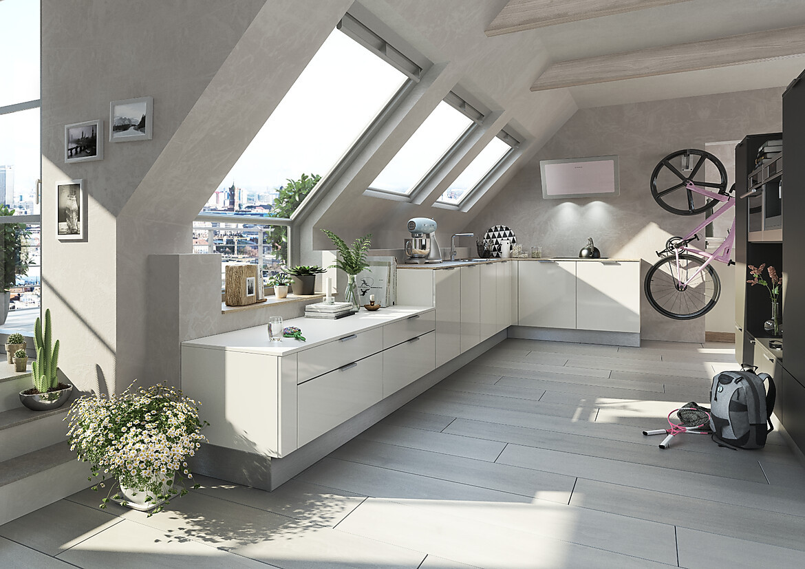 Eine Küche unter der Dachschräge einzuplanen kann eine Herausforderung sein. Ohne Oberschränke kommt diese großzügige und durchdachte Küchenzeile auf unterschiedlichen Höhen aus und lässt durch die weißen Lackfronten und die abgestimmte, dünne Arbeitsplatte den Raum luftig und groß wirken. Zuordnung: Stil Moderne Küchen, Planungsart L-Form-Küche