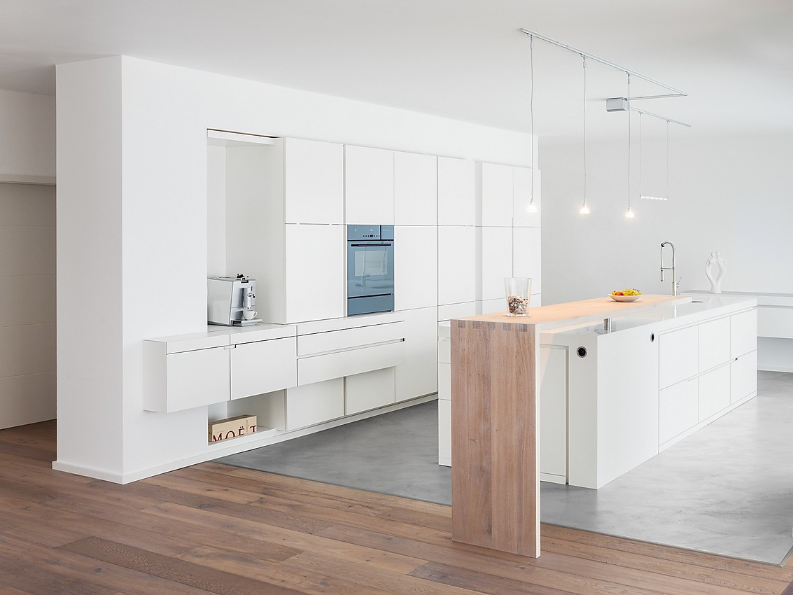 Moderne Küchenlösung aus weißem Corian mit Holzakzent. Zuordnung: Stil Design-Küchen, Planungsart Küche mit Küchen-Insel