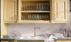 Oberschrank mit Geschirrhalter und weiße Spüle mit Nostalgiearmatur. Möbel in Sandgelb Strichlack Zuordnung: Stil Landhausküchen, Planungsart U-Form-Küche