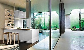 Einfarbige, offene, grifflose Küche mit breiter Theke Zuordnung: Stil Moderne Küchen, Planungsart Offene Küche (Wohnküche)