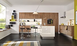 Weiße Hochglanzfronten und Holzfronten gehen hier eine beinahe zeitlose Partnerschaft ein. Die Farbkombination wirkt harmonisch, wohnliche Elemente wie Theke und Sitzbank gestalten den Übergang zum Wohnbereich gekonnt. Küchenzeile, Hoch- und Hängeschränke gewährleisten in der offenen Planung viel Stauraum und einen ergonomisch gut durchdachten Work-Flow. Zuordnung: Stil Moderne Küchen, Planungsart Küche mit Sitzgelegenheit