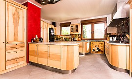 Hier dominieren runde Formen: Die Massivholzküche von Pfister hüllt den Raum in eine gemütliche Wohlfühlatmosphäre. Zuordnung: Stil Design-Küchen, Planungsart Innenausstattung der Küche