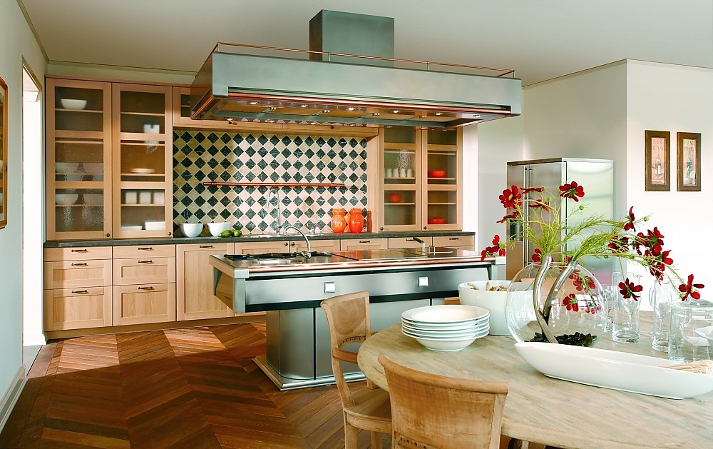 Offene L-Küche mit Holzfronten und Kücheninsel aus Metall mit großräumigem Dunstabzug Zuordnung: Stil Klassische Küchen, Planungsart Offene Küche (Wohnküche)