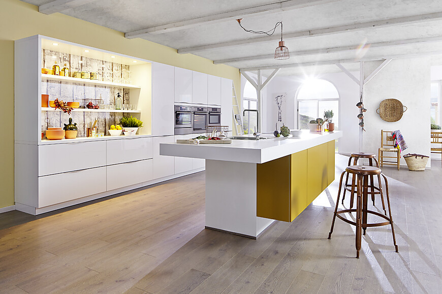 Offene Designküche mit Mix aus weißen und gelben Lackfronten (Bauformat Küchen)
