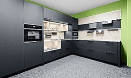 Diese L-Küche wirkt aufgrund der carbon-schwarzen Front sehr edel. Zur Gestaltung der Küchenrückwand und der Arbeitsplatte wurde ein helles Holzdekor genutzt, das alle Blicke auf sich zieht. Zuordnung: Stil Moderne Küchen, Planungsart L-Form-Küche