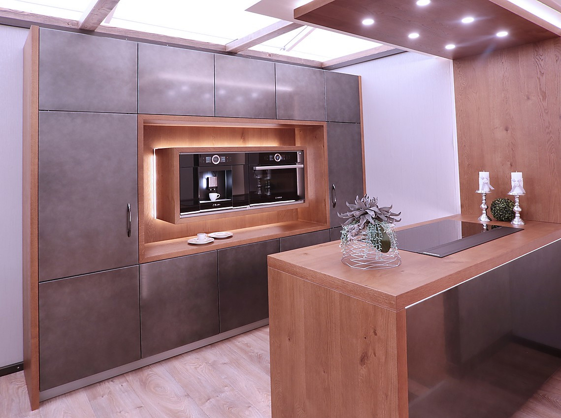 Dieses Küchenmodell ist ideal für Liebhaber exklusiver Designs: Glänzende Metallfronten wird umrahmt mit Eichenholz. Darauf ergibt sich ein besonders einzigartiges Erscheinungsbild. Zuordnung: Stil Moderne Küchen, Planungsart Küche mit Küchen-Insel
