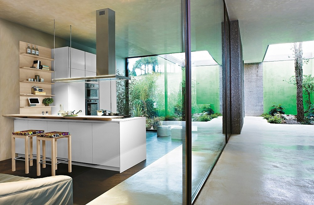 Einfarbige, offene, grifflose Küche mit breiter Theke Zuordnung: Stil Moderne Küchen, Planungsart Offene Küche (Wohnküche)